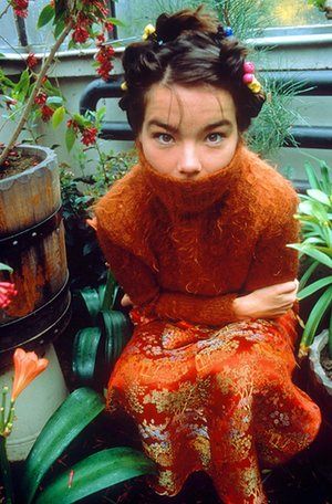 Björk in 1998, after the release of Homogenic. Red Dress, A Woman, Bench, Orange, Plants, Flowers, Red