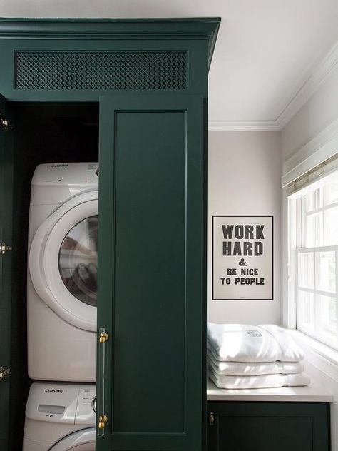 A white front loading stacked washer and dryer are hidden behind tall green cabinet doors finished with brass and lucite pulls. Washer And Dryer Hidden, Hidden Laundry Rooms, Stacked Washer And Dryer, Washer Dryer Laundry Room, Stackable Laundry, Room Organizers, Transitional Laundry Room, Room Pantry, Organization Laundry