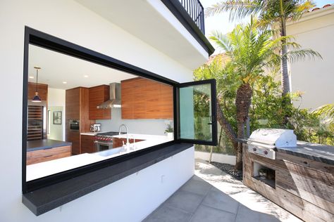 This bifold window connects the kitchen to the barbeque. It allows a connection to the people sitting at the bar and the people in the kitchen. The natural reclaimed wood barbecue is contrasting the modern natural walnut cabinets in the kitchen. Servery Window Kitchen Bifold, Bifold Windows Bar, Kitchen Window Bar Counter Outside, Bifold Kitchen Window, Bifolding Windows, Bifold Windows Kitchen, Bifold Windows, Kitchen Window Bar, Kitchen Window Design