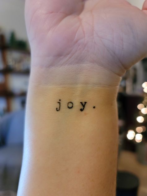 Small Joy wrist tattoo in typewriter font Joy Tattoo Ideas Design, Joy Name Tattoo, Joy Wrist Tattoo, Joy Tattoo Fonts, Count It All Joy Tattoo, Small Side Wrist Tattoos For Women, Tattoo Typewriter Font, Joy Tattoo Ideas, Discreet Tattoos For Women