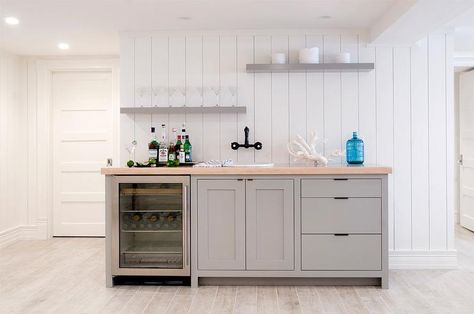 BASEMENT BAR - Amazing basement wet bar features a vertical shiplap wall lined with gray cabinets fitted with a glass door beverage fridge and an oval sink under a bronze wall mount sink as well as gray staggered floating shelves. Basement Family Rooms, Gray Basement, Wet Bar Basement, Basement Wet Bar, Basement Kitchenette, Basement Bar Designs, Decor Pad, Basement Kitchen, Basement Family Room