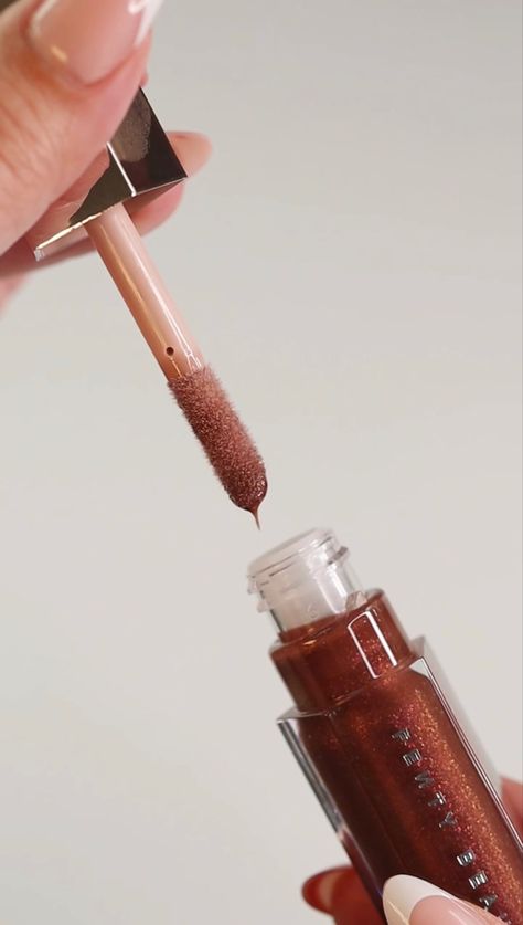 A shot of a Fenty Gloss Bomb Universal Lip Luminizer in Hot Chocolit being opened. Fenty Gloss Aesthetic, Fenty Beauty Hot Chocolate Gloss, Ugc Lip Gloss, Fenty Hot Chocolit Gloss, Beauty Content Creator Aesthetic, Fenty Hot Chocolate Lip Gloss, Fenty Beauty Aesthetic, Cosmetics Photoshoot, Lip Gloss Aesthetic