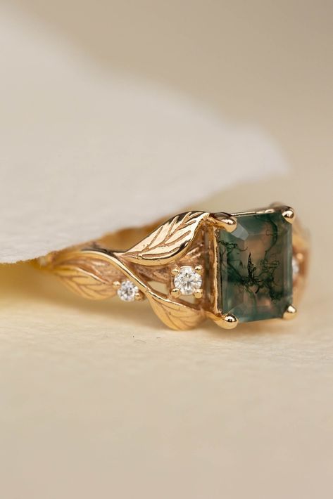 Discover the Clematis engagement ring, a handcrafted solid gold band featuring a stunning emerald cut gemstone with a modern twist. Inspired by nature, this alternative engagement ring is perfect for those seeking unique beauty. Choose from a variety of gemstones, including moss agate. Learn more at www.edengardenjewelry.com or contact us at info@edengardenjewelry.com for assistance. Men’s Emerald Engagement Rings, Engagement Ring Gold, Ethical Engagement Ring, Nature Inspired Engagement Ring, Moss Agate Engagement Ring, Green Gemstone Ring, Dream Venue, Leaf Engagement Ring, Alternative Engagement Ring