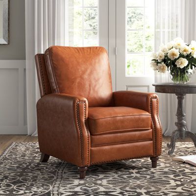 This manual leather recliner brings relaxation and a French country look to your living room or family den. Its solid and engineered wood frame has sinuous spring construction for lots of support, and it rests on bun feet with a glossy brown finish. Foam fill is wrapped in buttery leather upholstery in your choice of color, with elegant nailhead trim around the rolled arms. This recliner has a manual pushback feature that adjusts to two positions. We also love that the extra padding on the back Brown Leather Recliner Chair, Leather Recliner Chair, Leather Loveseat, Leather Recliner, Wing Chair, Nailhead Trim, Leather Chair, Leather Upholstery, Recliner Chair