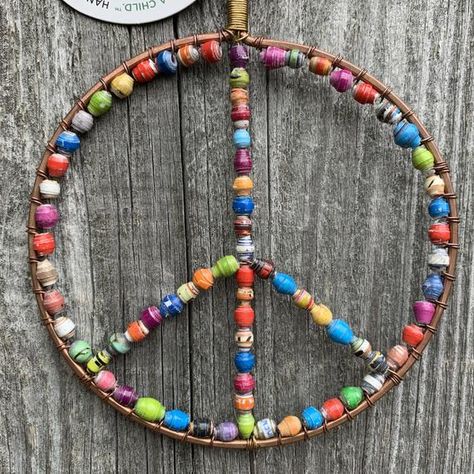 Our most popular ornament design! This original Peace Sign Paper Bead Ornament is handmade exclusively for Ornaments 4 Orphans by artisans in Uganda, East Africa. Colorful beads are rolled from strips of recycled paper, turning something ordinary into something extraordinary! This special ornament will hold a prominent place on your Christmas tree!  Dimensions: 5" high x 4" wide Materials: Recycled paper, copper wire, seed beads Country of Origin: Uganda Ornaments 4 Orphans is a member of the Fa Paper Bead Ornaments, Eclectic Large Beads For Festivals, Beaded Peace Sign Tutorial, Peace Sign Ornament, Peace Sign Wire Jewelry, Beaded Peace Sign, Peace Sign Art Hippie, Diy Hand Soap, Vintage Peace Sign Jewelry Gift