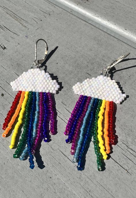 Looking for a fun and unique accessory that will add a pop of colour to any outfit? Check out our stunning cloud and rainbow fringe earrings! 🌈☁️ These handmade earrings are crafted from bright and colourful glass beads and carefully stitched together to create a whimsical design reminiscent of a fluffy cloud and a vibrant rainbow. Measuring approximately 6.5 cm in length (including the hoop), these earrings are lightweight and comfortable enough to wear all day long. Please note these are made to order so allow up to 1 week for dispatch.  Product details: Made with glass beads and either 925 sterling silver/gold plated earrings. All earrings are hypoallergenic.  Hoop size: 1.5cm Drop length: 6.5cm approx Please note that due to hygiene reasons, these earrings are non-refundable. Jeweller Unicorn Beaded Earrings, Fringe Earrings Diy, Cloud And Rainbow, Rainbow Fringe, Diy Rainbow, Beaded Jewels, Outfit Check, Rainbow Beads, Rainbow Earrings