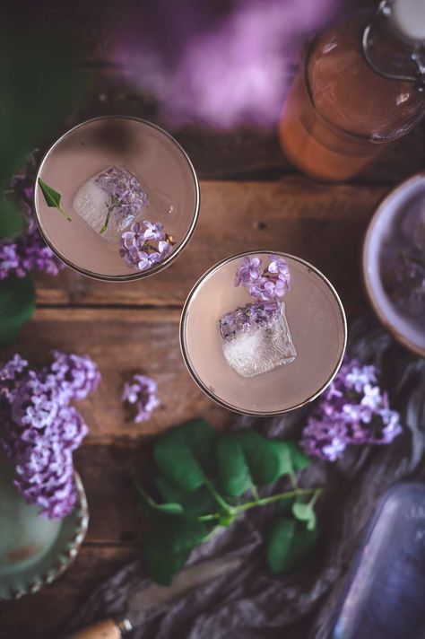 Use homemade lilac syrup to create this refreshing and beautiful spring Lilac Gin Fizz cocktail. | fareisle.com #lilacsyrup#lilaccordial#recipe#cocktails#drinks#summerdrinks#edibleflowers#lilac#cottagecore#drinkrecipe#cocktailrecipe#foodphotography#foodstyling Cottage Core Cocktails, Lilac Cottagecore, Lilac Recipes, Lilac Syrup, Flavored Carbonated Water, Gin Fizz Recipe, Fantasy Birthday, Vegan Key Lime, Gin Fizz Cocktail