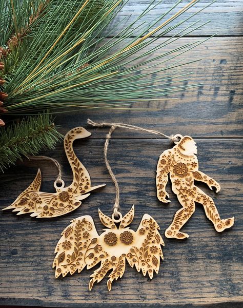 "This unique cryptid ornament set is done in Scandinavian Folk Art style with a beautiful pattern engraved on them that matches our Jackalope and Woodland Animal set. They are very lightweight- made of 1/4\" thick sealed birch or maple ply and measures about 4 1/2\" x 3\". You can use them as gift tags, everyday decor, or would make an awesome addition to your Christmas tree! Comes with a natural jute twine for hanging. Choose from Nessie, Mothman, Bigfoot, or save when you buy the whole set of Woodland Christmas Decor, Folk Art Ornament, Cottagecore Christmas, Creepy Christmas, Everyday Decor, Loch Ness Monster, Scandinavian Folk Art, Christmas Time Is Here, Loch Ness