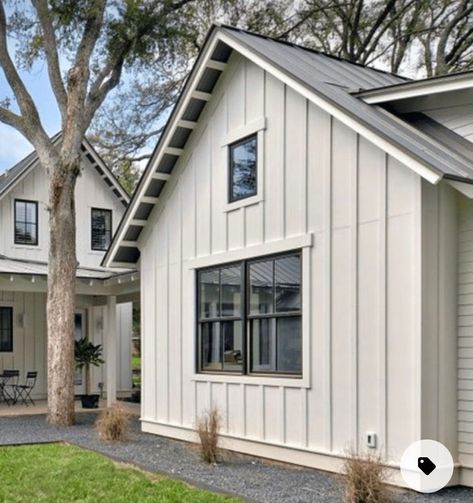 Creamy Grey House Exterior, Rambler Farmhouse Exterior, White House Vertical Siding, Board Batten Exterior Siding, Farmhouse Rambler Exterior, White Board And Batten With White Windows, Board And Batten Window Trim Exterior, Board And Batten Over Stucco, Cream House Black Windows