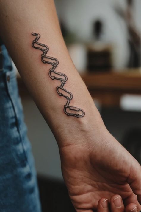 Tattoo of a stylized snake or chain pattern on a forearm. Small Wrist Tattoo Ideas, Minimalist Symbols, Small Wrist Tattoo, Rock Climbing Holds, Wrist Tattoo Ideas, Tiny Wrist Tattoos, Climbing Holds, Rock Textures, Adventurous Women