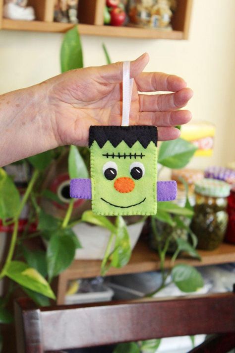 I love Halloween and I was inspired to make a series of Felt Halloween Ornaments for the season. This cute Frankenstein's Monster is one of 4 individual patterns. DIY digital PDF Felt Frankenstein's Monster Halloween Ornament and is designed for hand stitching using felt and embroidery thread. This cute Frankenstein's Monster Pattern can be used as an ornament or can made into a garland or a mobile. You can also enlarge the pattern to make a plush toy.  This felt Halloween Frankenstein's Monster is easy to make and the pattern includes a PDF file with 10 pages of step by step photos, instructions and full size patterns needed to complete the project. The completed felt Frankenstein's Monster ornament is approximately 4.25" wide and 3.75" high without the ribbon hanger. With the ribbon it's Felt Halloween Ornaments, Halloween Craft Treats, Frankensteins Monster, Felt Plush, Felt Monster, Felt Ornaments Patterns, Hallowen Ideas, Monster Halloween, Holiday Deco