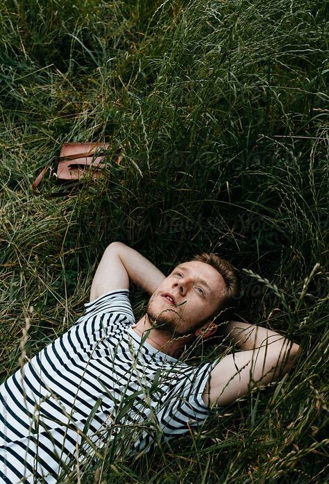 boy with striped shirt and jeans lying on the grass by Thais Varela for Stocksy United Park Portrait, Man Laying Down, Grass Man, Kids Lying, People Lie, Men Lie, Nature Photoshoot, Girl Sleeping, Figure Poses