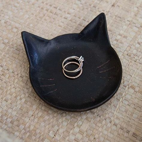 The Black Cat Tray is a shallow black resin tray in the shape of a cat face. The tray is made complete with subtle distressed details and whisker indents. This tray makes a great gift and can be used to hold jewelry, keys, or other small trinkets. Measures 1" high by 4" long by 3.75" wide. Cat Clay Tray, Black Cat Pottery, Clay Jewelry Tray, Cat Ashtray, Trinkets Dish, Cat Trinket Dish, Black Clay Pottery, Ceramics Cat, Resin Trinket Tray