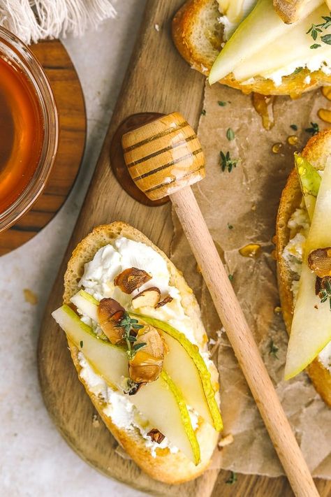 Make these pear appetizers in under 20 minutes! Crostini topped with goat cheese, sliced pear, toasted almonds & honey are the perfect bite for the holidays. Easy to make and delicious! Bacon Wrapped Pears, Pear And Goat Cheese Crostini, Brie Pear Crostini, Pear Hors D’oeuvres, Pear Crostini Appetizers, Prosciutto Pear Appetizer, Pear And Cheese Appetizer, Pear Bruschetta Appetizers, Pear Goat Cheese Appetizer