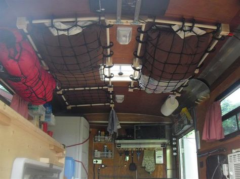 Two cargo nets are attached to a tiny trailer's ceiling and storing clothes. Toy Hauler Conversion, Rv Hacks Travel Trailers, Travel Trailer Interior, Car Ceiling, Kangoo Camper, Kombi Motorhome, Cargo Trailer Conversion, Cargo Trailer Camper, Tiny Trailers