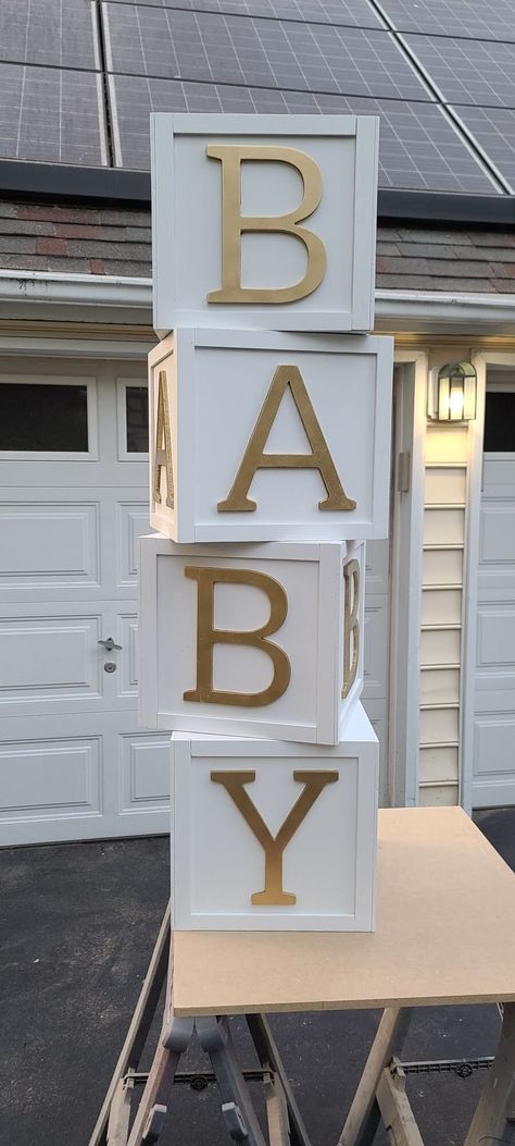 "Do you want to make your baby shower POP? Are you an event planner looking for some modern show stopping decor for your next event?  Check out these gorgeous BABY blocks!! These are handmade wood, hollow baby letter blocks. We have different size variations, 10x10, 12x12, 14x14, 16x16 and can go bigger or smaller. The blocks pictured are painted white with gold letters. The letters are placed around the entire box (except top and bottom) so the word \"BABY\" can be read from all angels.  *We ca Alphabet Boxes Decor, Baby Shower Boxes Diy, Baby Shower Setup Ideas, Diy Baby Blocks Decoration, Baby Boxes Decorations, Baby Blocks Baby Shower Diy, Baby Blocks Decoration, Baby Cubes, Wooden Baby Blocks