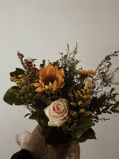 Flower bouquet with green leaves, light pink roses and sunflowers in a mesh cloth base against a white background Fall Sunflower Bouquet, Sunflower Bouquet Wedding, Feed Filler, Bouquet Sunflower, Filler Pics, Fall Bouquet, Sunflower Wedding Bouquet, Sunflower Bouquet, Sunflower Bouquets