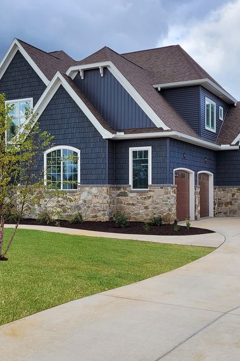 This Craftsman Cottage features our Silver Patina Webwall on the exterior. The earth and shadow tones of this natural stone complement the deep blue siding color of the house leaving a beautiful masterpiece. Navy Blue House Exterior White Trim Brown Roof, Homes With Blue Siding, Deep Blue Siding House, Dark Navy Siding Exterior, Navy House With White Trim, Dark Grey Colonial House Exterior, Exterior Two Tone House Colors, Navy Blue Siding With Brick, Houses With Blue Siding