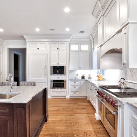 This large kitchen showcases a two-tone concept with an expansive dark wood island.   The transitional style makes the space feel rustic and traditional, but still has modern touches and accents. The cabinetry and island are all custom and done by our team at Teoria. White Shaker Cabinets With Wood Island, Dark Wood Bottom White Top Cabinets, White Kitchen Cabinets With Dark Wood Island, White Oak Floors Dark Cabinets, White Kitchen With Dark Wood Island, Dark Wood Island With White Cabinets, White Kitchen Cabinets Wood Island, Traditional Kitchens With Islands, Dark Wood And White Kitchen