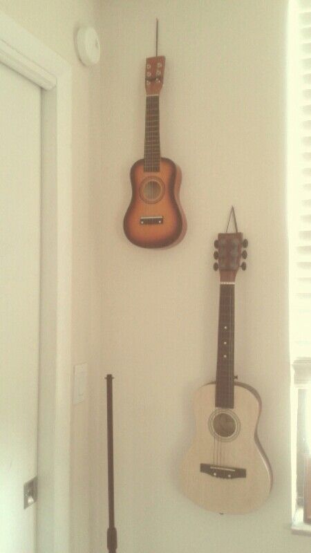 Guitars hanging on wall (just used birthday ribbon and hammered a nail) Hang Guitar On Wall, Hippie Room Inspo, Guitar Hanging Ideas, Guitar Stand Wall, Hanging Guitars, Birthday Ribbon, Hippy Room, Guitar Wall, Walls Room