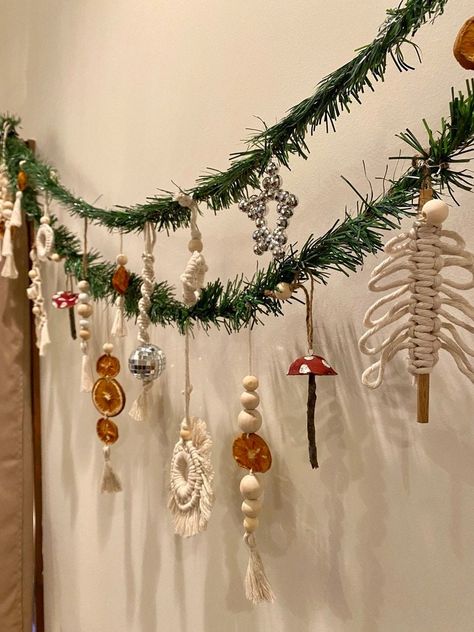 Deck the halls with our Handmade Christmas Garland, a stunning blend of Boho, Rustic, and Festive charm! 🎄✨ This versatile garland features 10 individual Handmade Ornaments, each bringing a touch of Unique Artistry to your Holiday Decor. 🌿 Garland Features: *10 handmade ornaments attached to sturdy green garland. *Variety of ornaments include macramé creations, dried orange decor, whimsical mushroom ornaments, rustic wood beads, and dazzling disco balls. *Each ornament is carefully crafted for Wood Garland Decor Ideas, Handmade Christmas Garland, Boho Christmas Ornaments Diy, Hippie Christmas Decor, Nordic Garland, Diy Boho Christmas Decor, Boho Christmas Aesthetic, Earthy Christmas Decor, Organic Christmas Decor