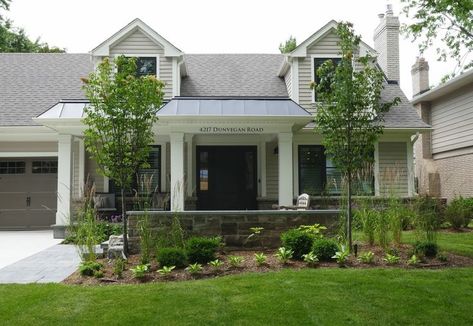 A pretty house with curb appeal in a posh residential neighborhood. The house has landscaped and hardscaped elements including porch pillars and a stone half wall in the front yard. Creating Curb Appeal, Stone Skirt, Exterior Home Renovation, Porch Pillars, Exterior Columns, White Porch, Burlington Ontario, Front Walkway, Treated Timber