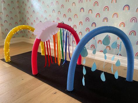 Rain, rainbow, sun arch set up using Support Beans Rain Sensory Play, Infant Obstacle Course, Line Up Spots On Floor Preschool, Baby Daycare Room, Infant Playground, Rain Activities, Toddler Movement Activities, Rainbow Arch, Diy Sensory Toys For Babies