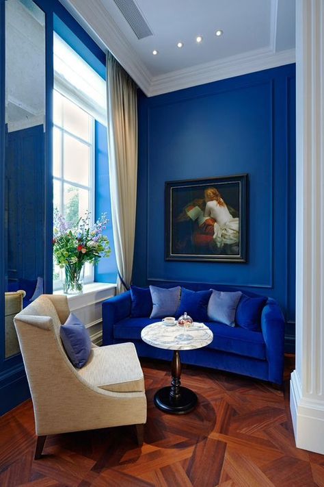 blue velvet sofa in bright blue living room, wood parquet floors, cobalt blue, sapphire blue, electric blue Blue Velvet Sofa Living Room, Good Living Room Colors, Velvet Sofa Living Room, Blue Velvet Sofa, Living Room Color Schemes, Waldorf Astoria, Room Color Schemes, Amsterdam City, Blue Sofa