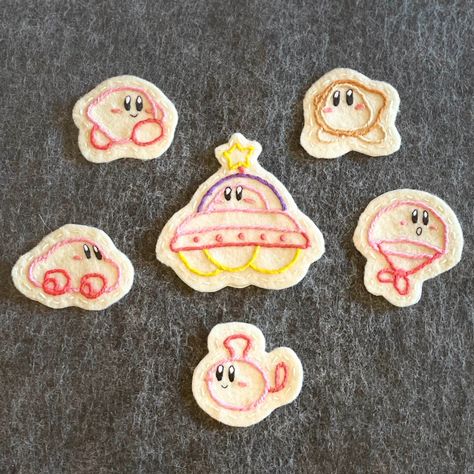 These hand-embroidered felt patches are inspired by Kirby's Epic Yarn! They have an iron-on adhesive backing for secure attachment to any jacket, bag, etc.! They can also be stitched on.  Note: Every design is hand-embroidered, making each piece unique! Your made-to-order patch may look slightly different from the one in the display pictures, but all the details will be exactly the same. Washing instructions: Color does not bleed when machine-washed. Iron-in adhesive is not machine-washable, but can be machine-washed if sewn on first. Delicate setting recommended. Kirby Yarn World, Pikmin Embroidery, Kirby Crafts, Kirby Outfit, Kirby Embroidery, Video Game Embroidery, Embroidered Felt Patch, Felt Patches, Waddle Dee