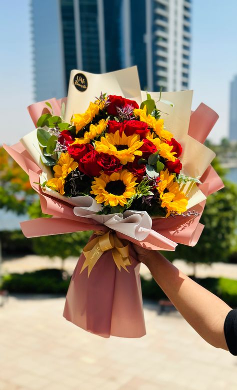 A Bouquet Of Sunflowers & Red Roses in pink & brown wrapping with a golden ribbon and a UAE Flowers sticker on top. Luxury Florists, Flowers Peonies, Online Flower Delivery, Red Rose Bouquet, Fresh Flower Delivery, Sunflower Bouquets, Florist Shop, Line Flower, Luxury Flowers