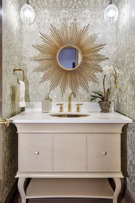 Sparkling damask wallpaper creates a stunning glamorous setting for this powder room. A pair of contemporary pendant lights flank a golden sunburst mirror for an eye-catching focal point. The curvy white vanity features gold fixture, bringing a feminine quality to the space. Bathroom Wallpaper Gold, Gold Wallpaper Bathroom, Transitional Powder Room, Bathroom Vanity Storage, Unique Bathroom Vanity, Wallpaper Gold, Galley Kitchen Remodel, Wallpaper Bathroom, White Bathroom Designs