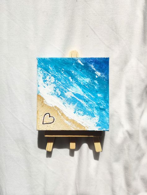 A hand-painted mini canvas painting of ocean waves meeting a beach with a heart drawn in the sand. Easel included. I'm more than happy to accept custom orders! Just give me a message. I pack all of my orders with recycled and recyclable materials to be as eco-friendly as possible! Ideas To Paint On Tiny Canvas, Beach Mini Canvas Painting, Miniature Acrylic Painting Mini Canvas, Easy Painting Ideas Beach, Tiny Acrylic Painting Mini Canvas, Mini Beach Paintings, Beach Easy Painting, Small Canvas Paintings Aesthetic, Summer Canvas Painting Ideas