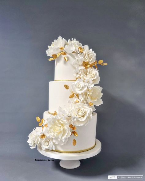 A three tier cake in ivory with beautiful sugar flowers cascading around the cake.  Gold sugar leaves and a touch of gold to the centre of the flowers Sugar Flowers, Touch Of Gold, Wedding Theme, Wedding Cakes, Cake, Flowers, Gold, White