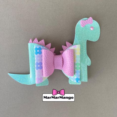 Unique hand crafted Dinosaur bow from MarMarMango. Shop our Etsy to see all the new styles. #bow #hairclip #hairbow #girl #birthdaygift #uniquebow #dinosaur #dinobow Diy Dinosaur Headband, Disney Hair Bows Diy, Dinosaur Hair Clip, Garland Table Runner, Disney Faux Leather Bows, Dinosaur Cupcake Toppers, Dinosaur Cupcakes, Unique Bows, Indoor Games For Kids