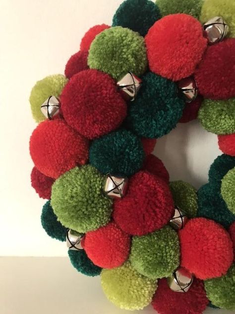 a bright red and green pompom Christmas wreath with little bells is a bold holiday decoration you can make yourself Green Wreath Christmas, Christmas Pompom, Christmas Pom Pom Crafts, Pompom Crafts, Pompom Art, Scout Projects, Pom Pom Decor, Door Wreath Christmas, Christmas Pom Pom