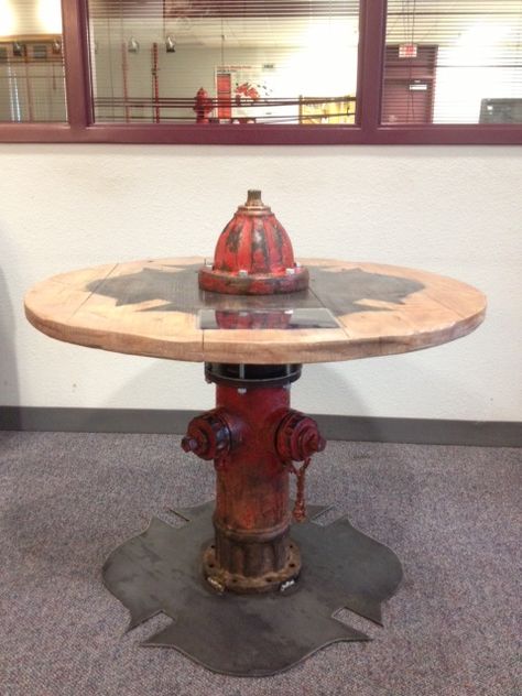 Round table made with a fire hydrant as the centerpiece. #texasfurniturebuilders #tfb #firehydranttable Firehouse Decor, Fire Dept Decor, Firefighter Man Cave, Fire Department Decor, Fire Crafts, Wood And Metal Table, Cable Reels, Firefighter Decor, Firefighter Love