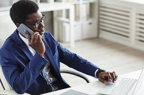 African businessman at work by AnnaStills. African businessman in suit sitting at his workplace typing on computer keyboard and talking on mobile phone at office #Sponsored #suit, #sitting, #workplace, #AnnaStills Typing On Computer, Typing On Laptop, Working On Computer, Africa Photography, Black And White Couples, Office Worker, Black Office, Business Lifestyle, Job Fair