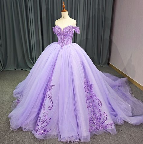 Elevate your evening in this opulent Sparkling Purple Sweetheart Quinceanera Dress. The basque waistline and gathered pleated skirt are adorned with lace florals, while the corset-style bodice, off-the-shoulder cuff sleeves, and hand-beaded details exude luxury. With a lace-up back and train, this gown ensures a flattering, adjustable fit. material: organza, glitter tulle, lace type: ball gown style: formals color as shown built in bra sweetheart neckline train as shown lace up back Purple Dresses Quinceanera, Lavender Ball Gowns, Light Purple Quinceanera Dresses, Purple Quince Dress, Purple Quinceanera Dresses, Quinceañera Dresses, Train Birthday Party, Pretty Quinceanera Dresses, Mini Wedding Dresses