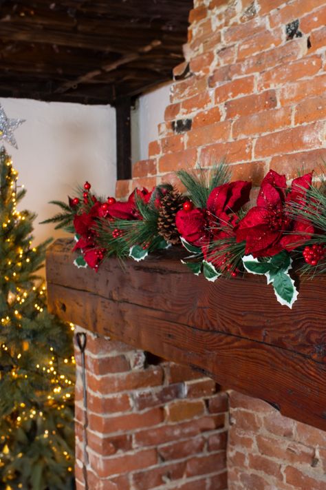 Red faux poinsettia and pine garland over brick fireplace. Christmas Fiesta, Faux Christmas, Poinsettia Flowers, Red Poinsettia, Poinsettia Flower, Festive Look, Christmas Inspo, Holly Berries, Christmas Collection