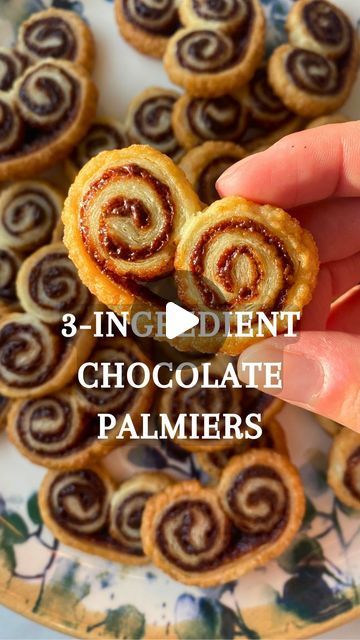 Katja & Youssef 🇩🇪🇲🇦 on Instagram: "3-INGREDIENT CHOCOLATE PALMIERS 🍫👩‍🍳 Recipe below 👇

Palmiers cookie are one of my favourites, and I love this version using @nocilla palm oil free chocolate spread! 

To make a batch (~30) you’ll need
👉 1 sheet puff pastry 
👉 2 tbsp sugar 
👉 2 generous tbsp @nocilla spread (or spread of your choice) 

1. Sprinkle 2 tbsp sugar on a clean surface and lay puff pastry on top
2. Spread chocolate spread on top until the edges, and roll both sides in 
3. Refrigerate your log for 30 minutes for easier cutting, then cut your log into 1/2 cm (1/4 inch) slices
4. Bake for 12-15 minutes at 180C (325F)

FOLLOW @kayoukitchen for simple and delicious recipes EVERY WEEK 😋

Enjoyyy,
Katja & Youssef 🥰

#palmier #palmiercookies #french #easy #easybaking #cook Sweet Puff Pastry Recipes, Puff Pastry Cookies, Palmiers Recipe, Palmier Cookies, Sweet Puff Pastry, Puff Pastry Recipes Dessert, Pastries Recipes Dessert, Puff Pastry Desserts, Easy Puff Pastry