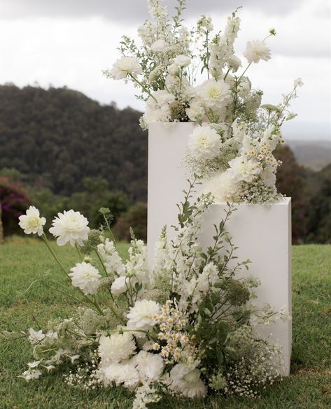 May Wedding Flowers White, Flower Plinths Ceremony, White Pedestal Wedding Ceremony, Ceremony Florals On Pedestals, Ceremony Backdrop Flowers, All White Modern Wedding Flowers, Plinths Wedding Ceremony, White Wedding Design, Flowers At Alter For Wedding