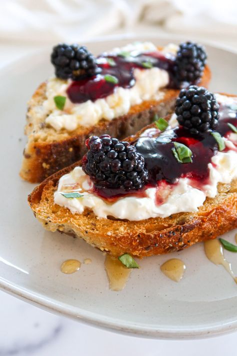 This incredibly delicious and easy recipe features toasted bread covered in creamy burrata cheese and blackberry jam! Top everything off with a drizzle of honey and some fresh basil leaves and get ready for the best breakfast you've ever had. Burrata toast requires only 6 simple ingredients: good bread, creamy burrata cheese, blackberry jam, blackberries, honey and fresh basil leaves. You can also use agave or maple syrup as a substitute for honey. The whole family will love this special treat! Jam And Cheese Toast, Sourdough Topping Ideas, Leftover Sourdough Bread, Burrata Toast, Fancy Toast, Burrata Recipe, Fruit Toast, Quick Easy Breakfast, Jam Toast