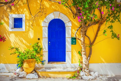 Colors that compliment Yellow - Mustard Yellow House with Blue Door Bold Front Door, Yellow House Exterior, Mediterranean Homes Exterior, Stucco Siding, Old Wooden Doors, Yellow House, Roof Colors, Yellow Houses, Front Door Colors