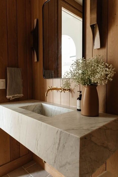 Stylish moody guest bathroom with rich wood paneling, a sleek marble floating sink, and elegant dark accents. Wood Paneled Powder Room, Natural Powder Room, Wood Panel Bathroom Wall, Floating Sink Bathroom, Wood Panel Bathroom, Quaint Cabin, Floating Sink, Wood Wall Bathroom, Oak Interior