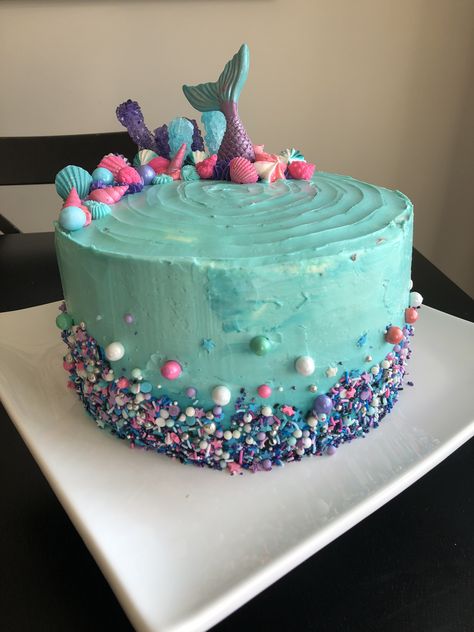 Chocolate cake with raspberry filling frosted with Swiss meringue buttercream.  Decorated with a homemade sprinkle blend, meringue kisses, chocolates and candy. Mermaid Sprinkle Cake, Easy Mermaid Birthday Cake, Mermaid Birthday Cake Buttercream, Chocolate Mermaid Cake, Homemade Mermaid Cake, Mermaid Cake Diy, Rainbow Mermaid Cake, June Birthday Cake, Simple Mermaid Birthday Cake