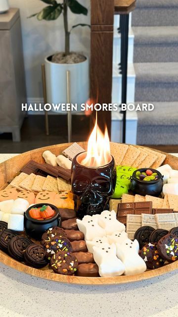 Kristin Miller | Creator | Dallas, TX on Instagram: "Halloween smores board💀Comment “fun” to get everything sent directly to your DMs! This skull fire pit is a must have this spooky season! This would be great to bring to a halloween party or have for a date night at home. Save & share with someone you want to make this with🎃 • WHAT YOU NEED: • large board or tray • mini tabletop firepit • marshmallows • assorted chocolates and candies • graham crackers and cookies • skewers • • #halloweenideas #halloweensmores #smores #halloweendesserts #easydessert #partyideas #halloweenparty #foodboard #halloweenrecipes" Halloween Nacho Table, Fall Date At Home, Halloween Cookie Tray, Halloween Board Night, Halloween S’mores Charcuterie, Halloween S’mores Board, Fall Teen Party Ideas, Fall Bonfire Party Ideas Food, Smore Board Ideas