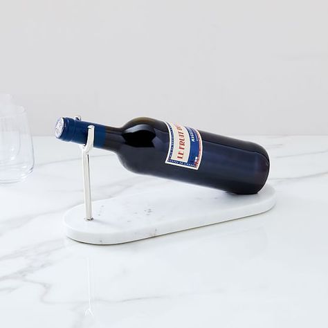 Designed to securely cradle a standard sized bottle of wine, this Nickel & Marble Wine Holder is a stylish way to protect your tables and countertops from pesky drips or condensation. KEY DETAILS 4.5"w x 12"d x 5.75"h. Hand-carved. Your purchase of handcrafted items helps preserve craft traditions worldwide. Learn more. Solid marble. Due to the natural materials used, variations in marble veining will occur. Steel base in a Nickel finish. Fits most standard sized bottles of wine. Sold individual Marble Cheese Board, Marble Accessories, Stone Accessories, Marble Tray, Marble Decor, Bottle Of Wine, Marble Art, Wine Holder, Wine Bottle Holders