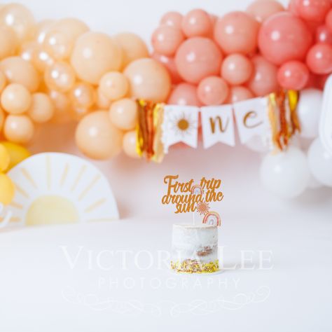 These twins are turning ONE! Mom decided on a First Trip Around the Sun theme, but boho style! We nailed it with a custom balloon garland and signs. These girls LOVED their cakes! Sun First Birthday Photoshoot, 1st Trip Around The Sun Cake Smash, First Trip Around The Sun Photo Shoot, First Trip Around The Sun Cake Smash, Sun Cake Smash, Trip Around The Sun Cake, Around The Sun Cake, Around The Sun First Birthday, Months Photoshoot