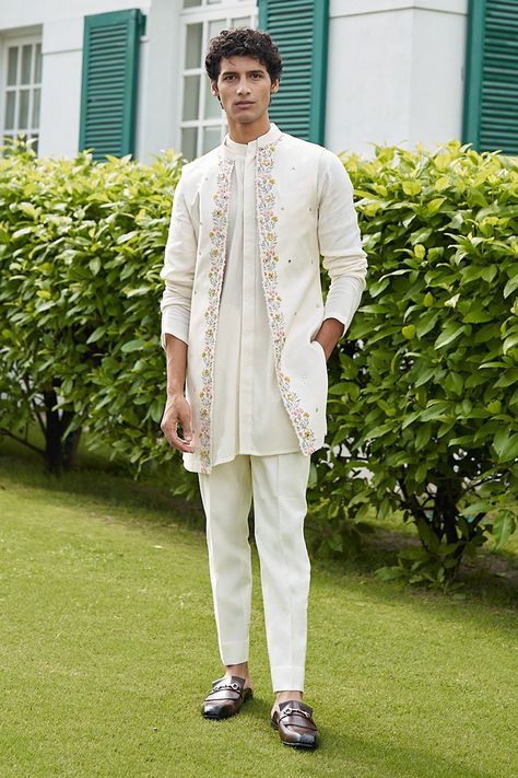 White front open jacket with floral embroidered motifs. Paired with kurta and pant.
Component: 3
Pattern: Embroidered
Type Of Work: Floral
Neckline: Jacket: Open
Sleeve Type: Kurta: Long
Fabric: Pure Silk
Color: White
Other Details: 
Weight (in gm): 800
Floral motifs
Occasion: Wedding - Aza Fashions Tulsi Vivah, Indian Wedding Clothes For Men, White Shrug, Wedding Kurta For Men, Groom Dress Men, Wedding Dresses Men Indian, Men's Wedding Outfit, Gents Kurta Design, Kurta Set For Men