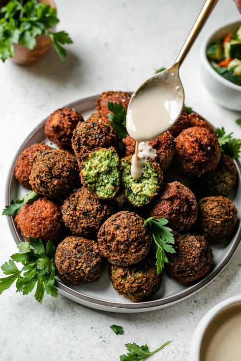 There's nothing better than golden brown Crispy Homemade Falafel! Choose your own adventure with this recipe – make traditional herbaceous green or harissa-spiked spicy red falafel. Either way, the result is light & airy fried falafel balls, perfect to enjoy on falafel salad, in a falafel sandwich or wrap, or mezze-style. Naturally vegan & easily gluten-free. Pan-fried, baked, air fryer, make-ahead instructions provided! #falafel #falafelrecipe #plantbasedrecipes #plantbasedmeals #veganrecipes Spicy Falafel Recipe, What Is Tahini Sauce, Gluten Free Falafel, Vegan Falafel Recipe, Falafel Balls, Homemade Falafel, Tahini Sauce Recipe, Falafel Salad, Lemon Tahini Sauce